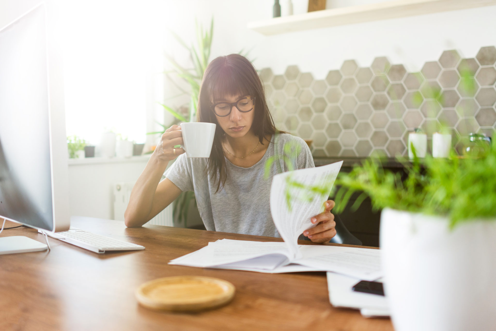 women reading paper drinking coffee