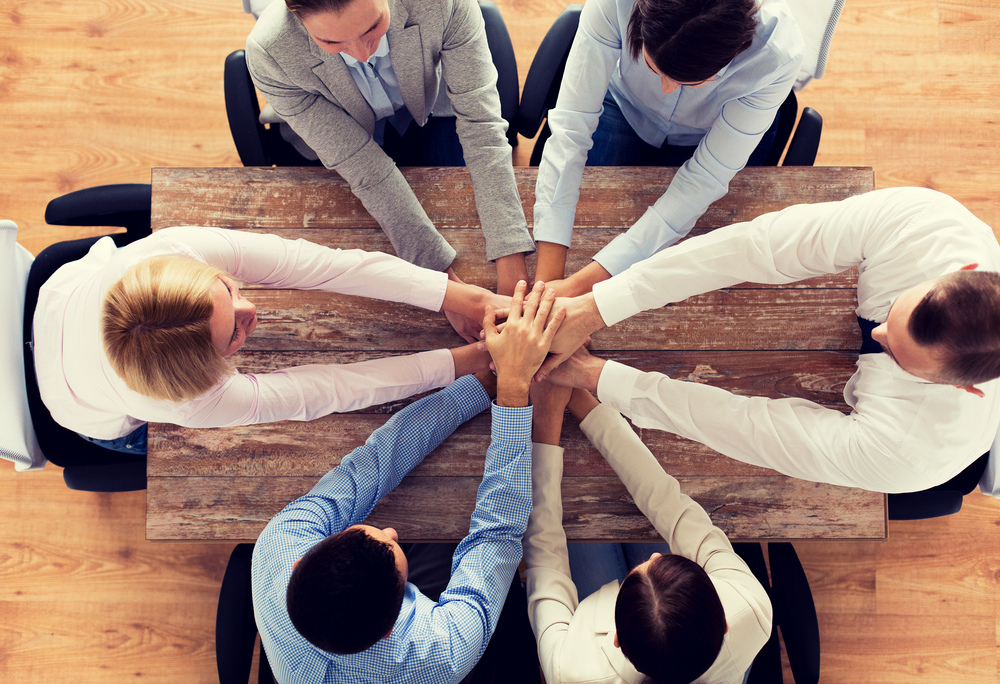 Group of people with hands in the middle